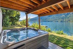 A hot tub under a wooden pergola with a view of a lake and forest. - Lakefront | Dock | Hot Tub | Deck | Dogs | Views (Leavenworth)