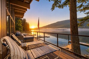A deck with outdoor seating, overlooking a lake with a misty mountain backdrop. - Lakefront | Dock | Hot Tub | Deck | Dogs | Views (Leavenworth)