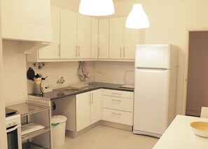 A compact kitchen with white cabinets, a refrigerator, a sink, and a stove. - A1- ★ Unique Property ★ Garden Mall - 10 seconds to metro - perfect for groups (Lisboa)