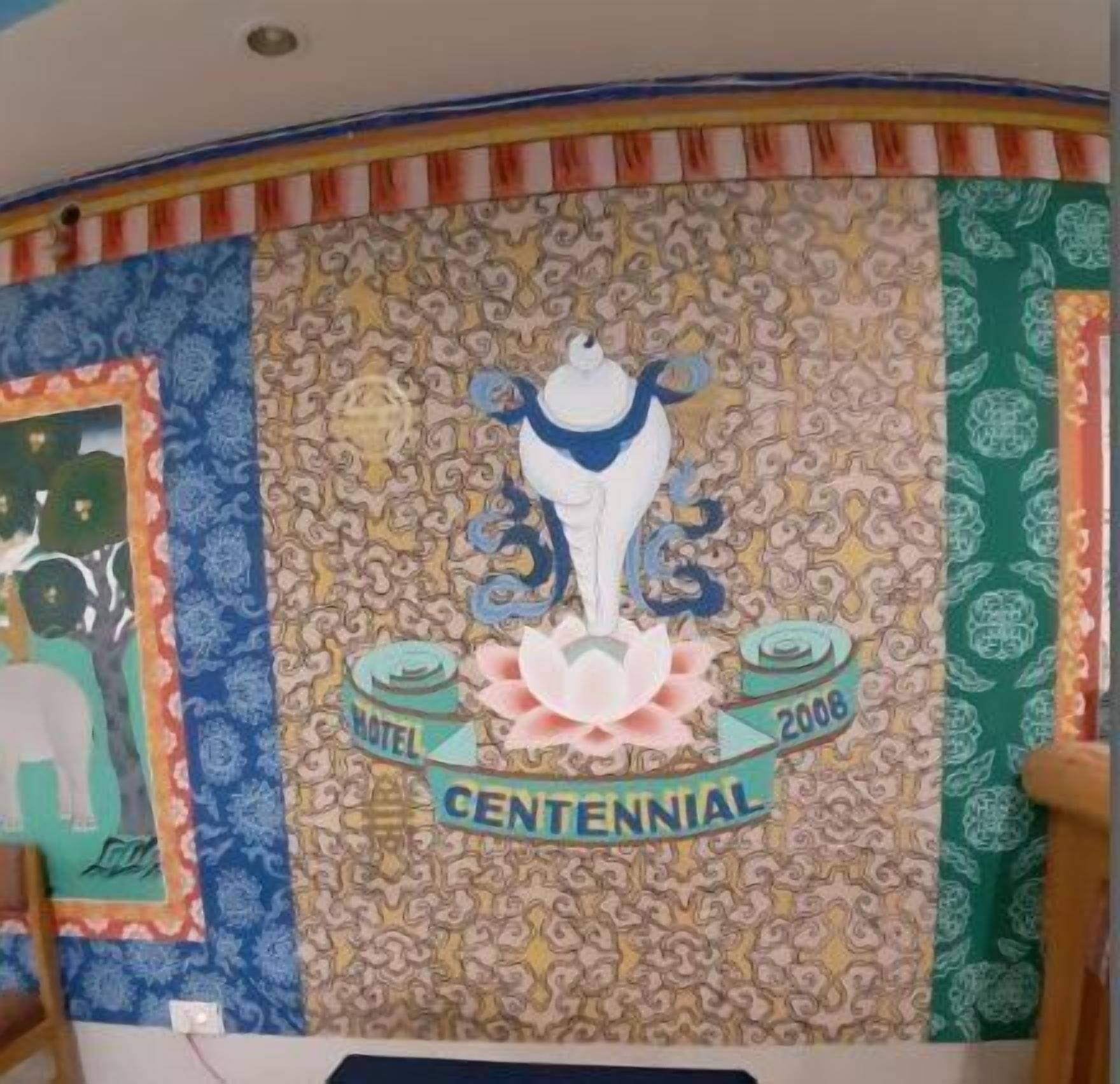 A wall with a decorative pattern and a central emblem with the text "Motel CENTENNIAL 2006".
