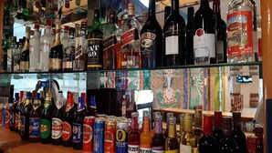 A bar with shelves stocked with various bottles of alcohol, including liquor, wine, and beer. - Centennial Hotel 2008 (Phuntsholing)