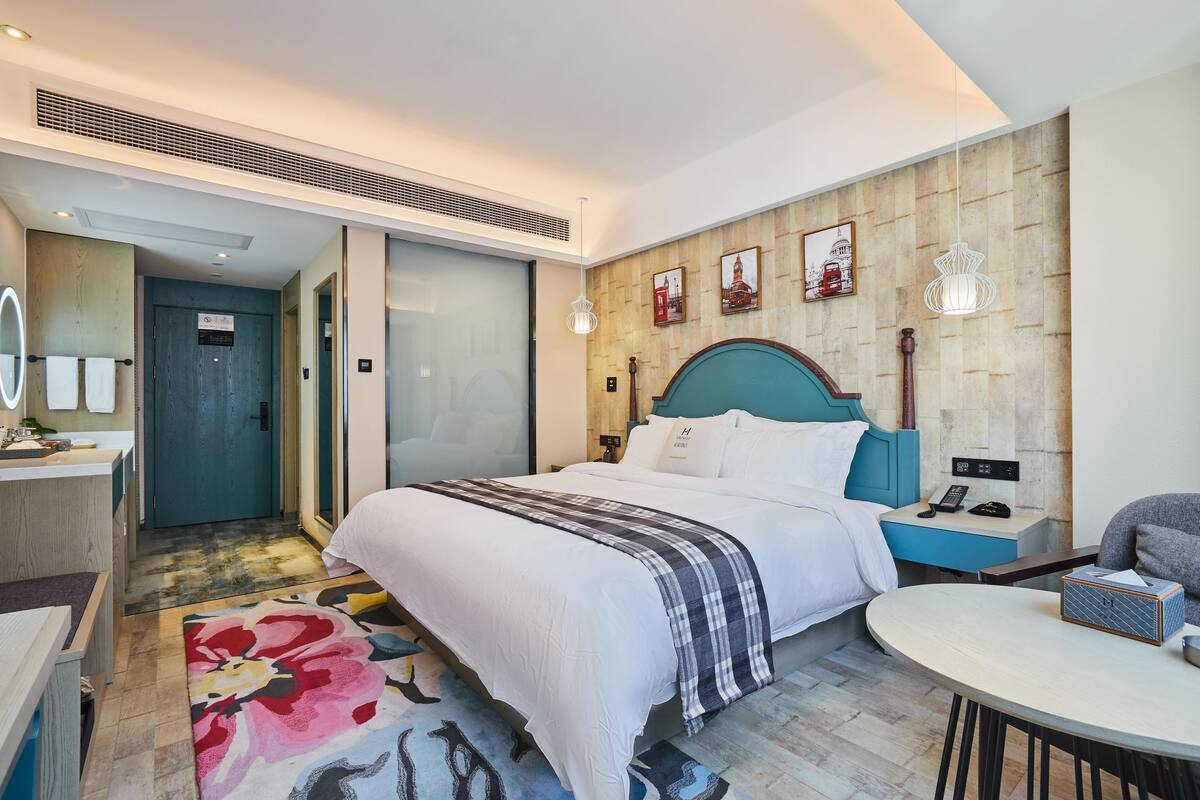 Une chambre d’hôtel comprenant un lit, une table de chevet, une commode et une table ronde.