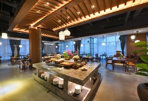 A modern dining area with a central buffet table, wooden ceiling, and pendant lighting. - S·dor Hotel Hangzhou Xiaoshan Airport (Hangzhou)