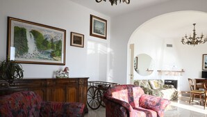 Ein Wohnzimmer mit Kamin, einem großen Gemälde und einer Chandeliebre.