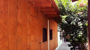 Ein Holzkorridor mit Tür und Fenstern, der zu einem Patio mit einem Tischkicker führt.