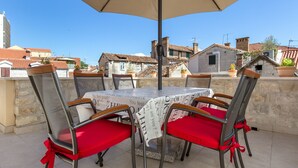 A terrace with a table and chairs, a beige umbrella, and a view of buildings. - APARTMENT ST. PETR OLD in SPLIT Downtown WITH GREAT SUNY TERRACE, area of ​​76m2 (Split)