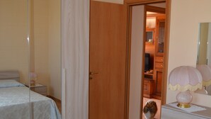 A bedroom with a bed, a dresser, a mirror, and a door leading to a bathroom. - Villa Lu Calabernardo (Contrada Calabernardo)