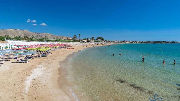 A beach with clear waters, sun loungers, and umbrellas. - Villa Lu Calabernardo (Contrada Calabernardo)