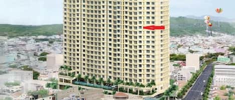 A high-rise hotel named 'GOLDSEA' with a central courtyard, a beachside location, and a view of the surrounding cityscape.
