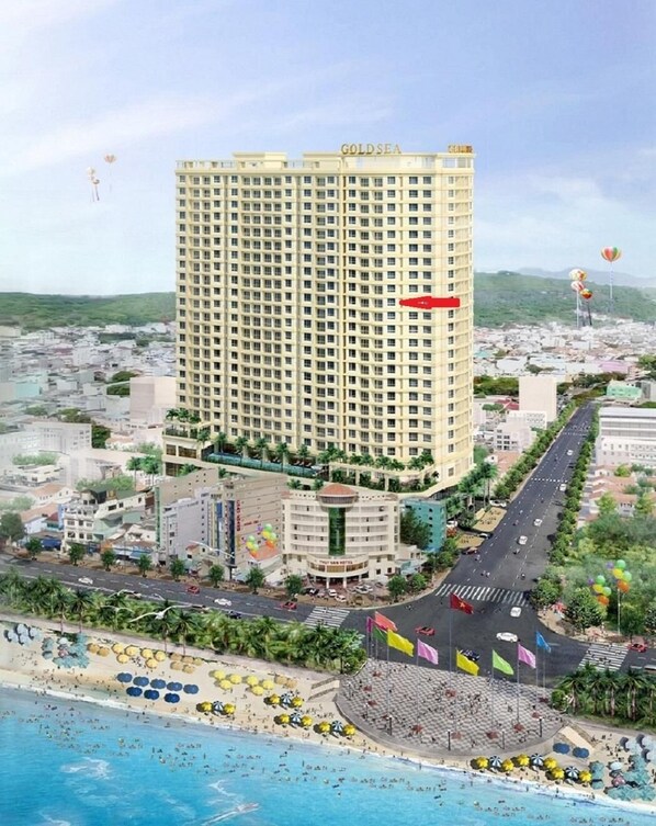 A high-rise hotel named 'GOLDSEA' with a central courtyard, a beachside location, and a view of the surrounding cityscape.