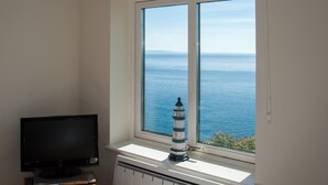 A room with a large window offering a view of the sea. - Marine Point, Mevagissey - sensational cliff top views of harbour and bay (Mevagissey)