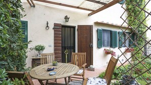 A wooden table and chairs set outdoors with a pergola overhead. - Chiantihouse near Florence (Montespertoli)
