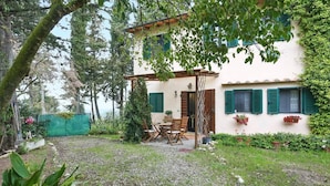 A two-story house with a garden, a dining area with a table and chairs, and a small porch. - Chiantihouse near Florence (Montespertoli)