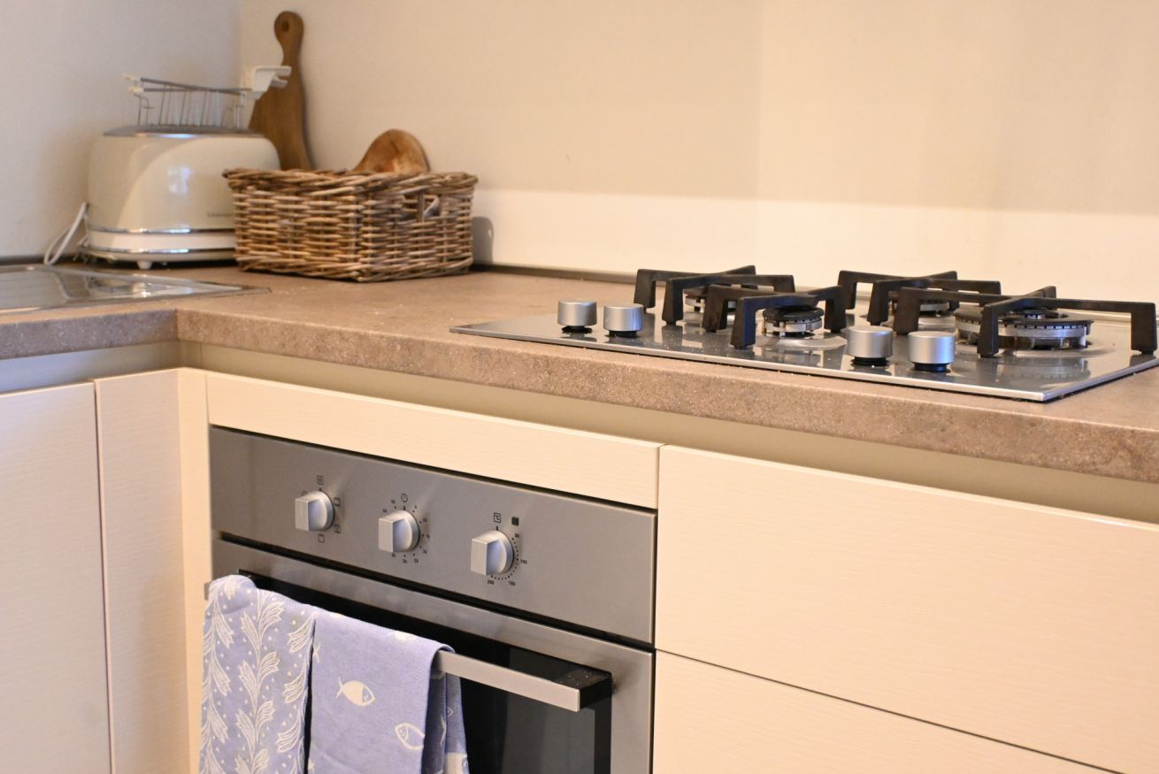 A kitchen with a gas stove, oven, and a toaster.