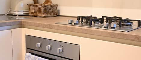 A kitchen with a gas stove, oven, and a toaster.