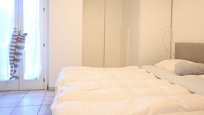 Een slaapkamer met een bed, een kledingkast en een raam.