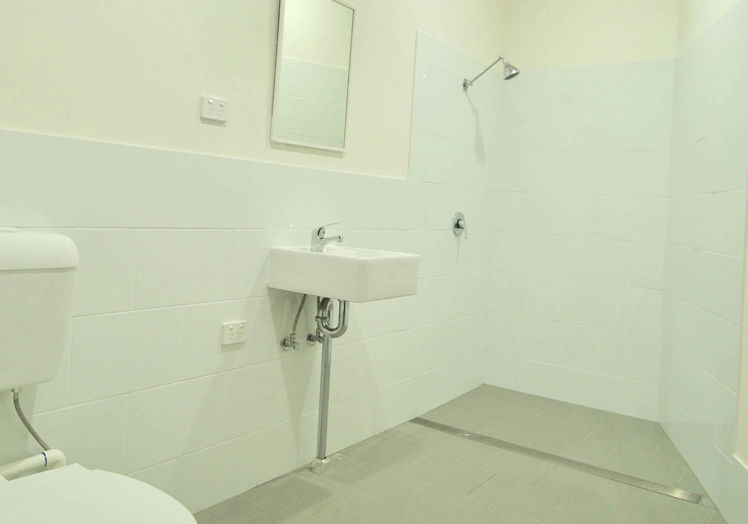 A bathroom with a toilet, sink, and shower.