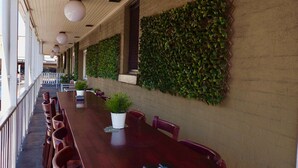 A long conference table with chairs, a potted plant, and a metal object on the table. - Argyle Hotel Southern Highlands (Moss Vale)
