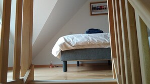 A bedroom with a bed, wooden staircase, and a framed picture on the wall. - MODERN DUPLEX APARTMENT? CENTRAL LOCATION - SLEEPS 5 (Le Bourg-d'Oisans)