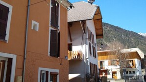 A street view of a building with a balcony, a street lamp, and string lights. - MODERN DUPLEX APARTMENT? CENTRAL LOCATION - SLEEPS 5 (Le Bourg-d'Oisans)