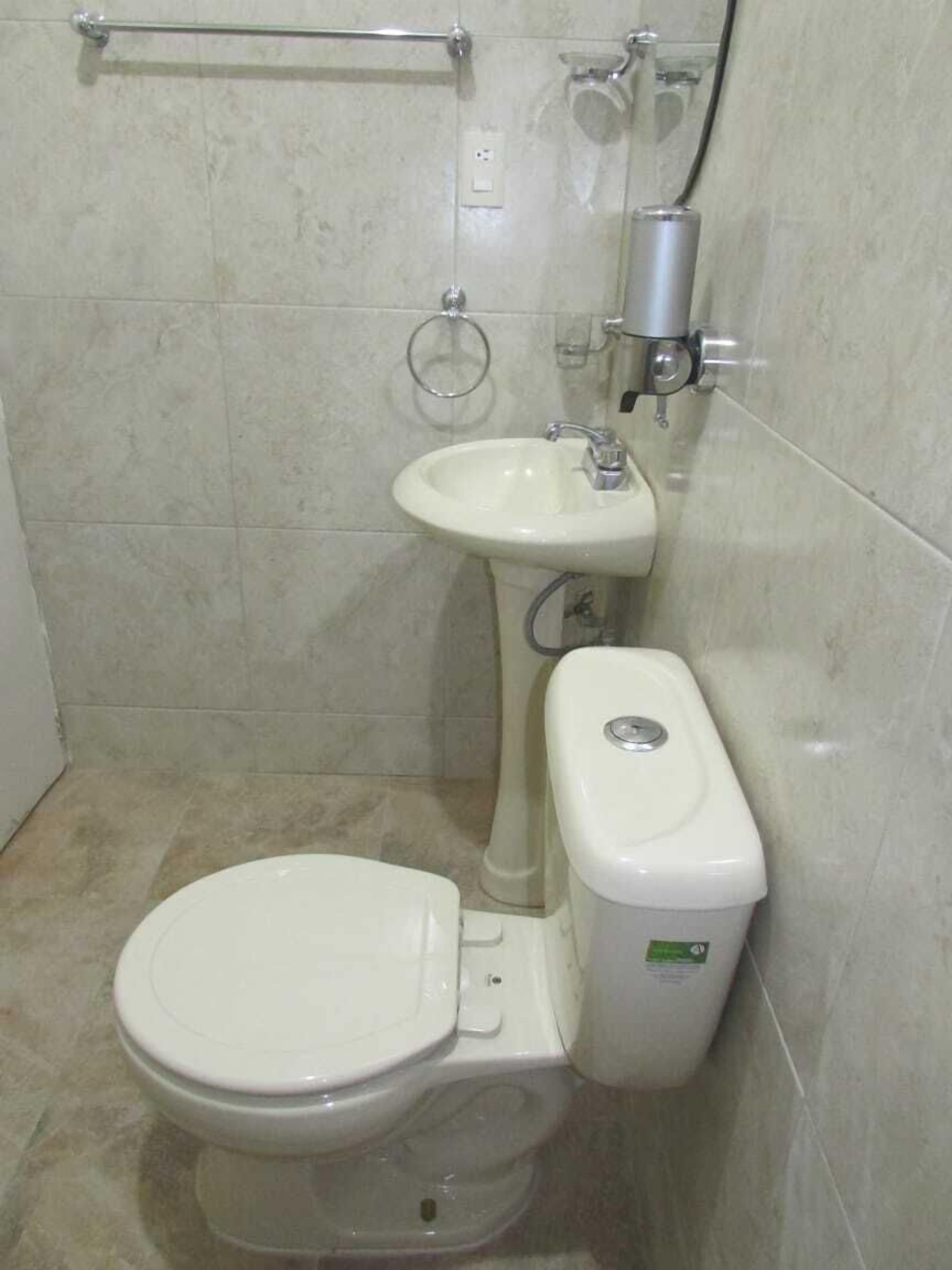 A bathroom with a toilet, sink, and shower.