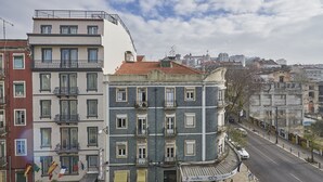 Un edificio de varios pisos con balcones y vista a la calle.