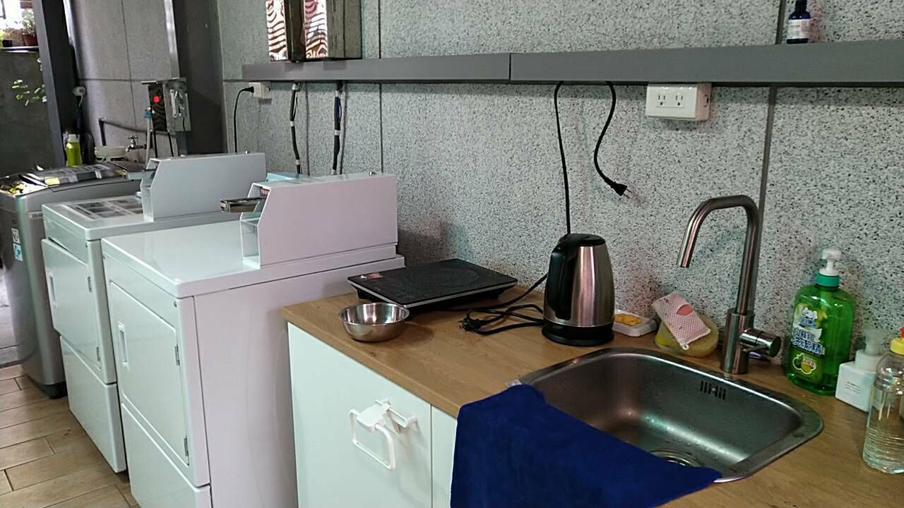 Une cuisine compacte équipée d’un évier, d’une bouilloire et d’un petit plan de travail.