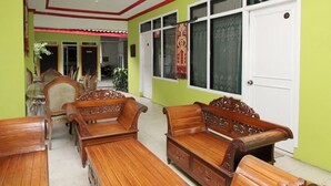 A room with wooden furniture, including benches and chairs, and a white door.