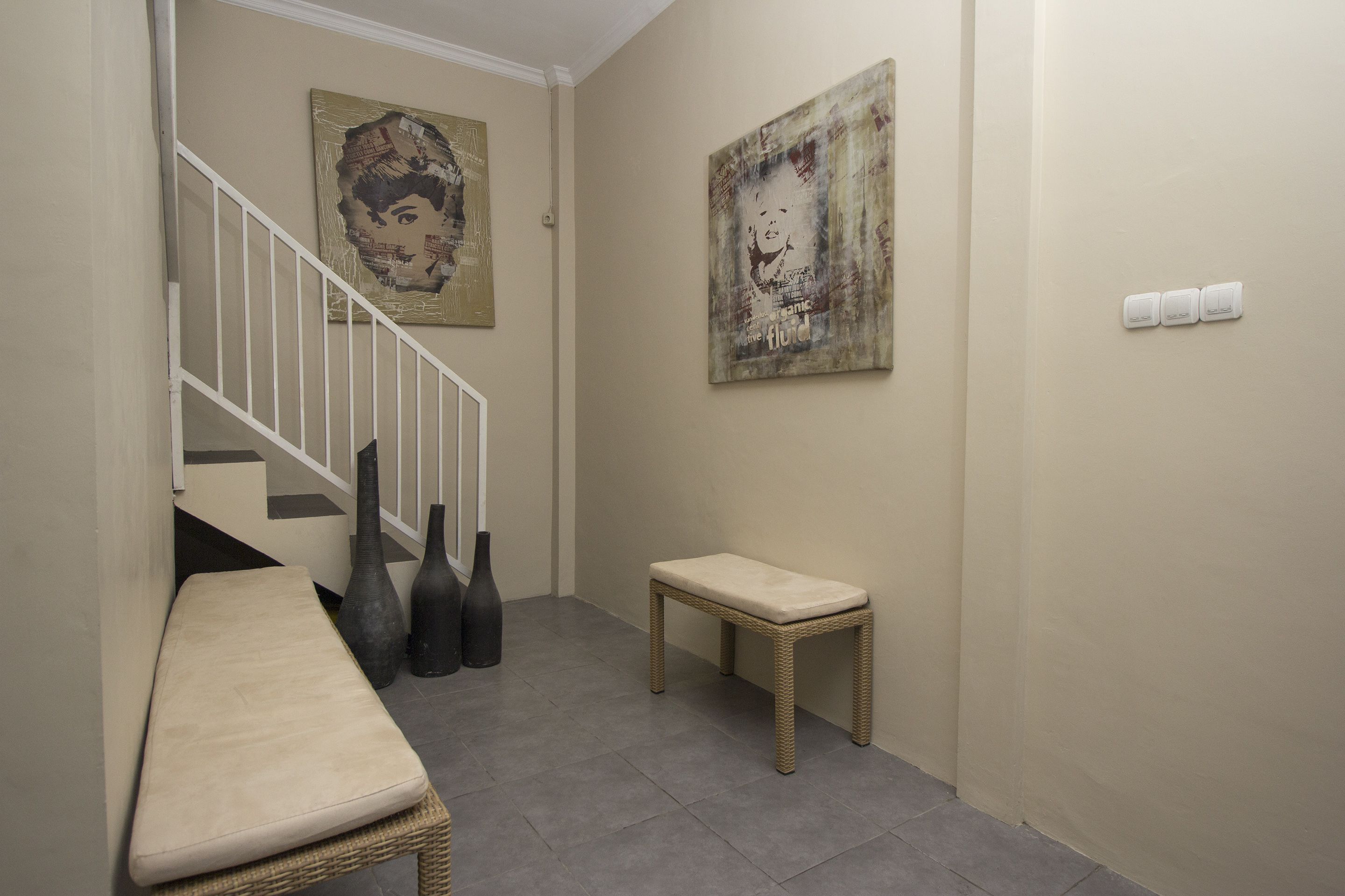 A hallway with a bench, a small table, and two vases.