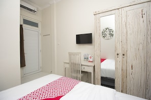 Une chambre à coucher comprenant un lit, un bureau, une chaise, une armoire, un téléviseur et un élément de décoration murale.