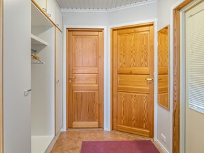 Stylish hallway with a shelf unit, window, and two doors.