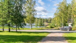 A gravel path leading to a lake with a car parked nearby.
