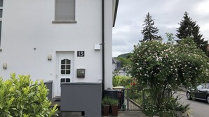 Un bâtiment blanc avec un panneau portant le numéro 13, une porte et une petite fenêtre.