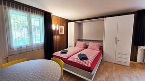 Habitació senzilla amb llit, taula i armari.