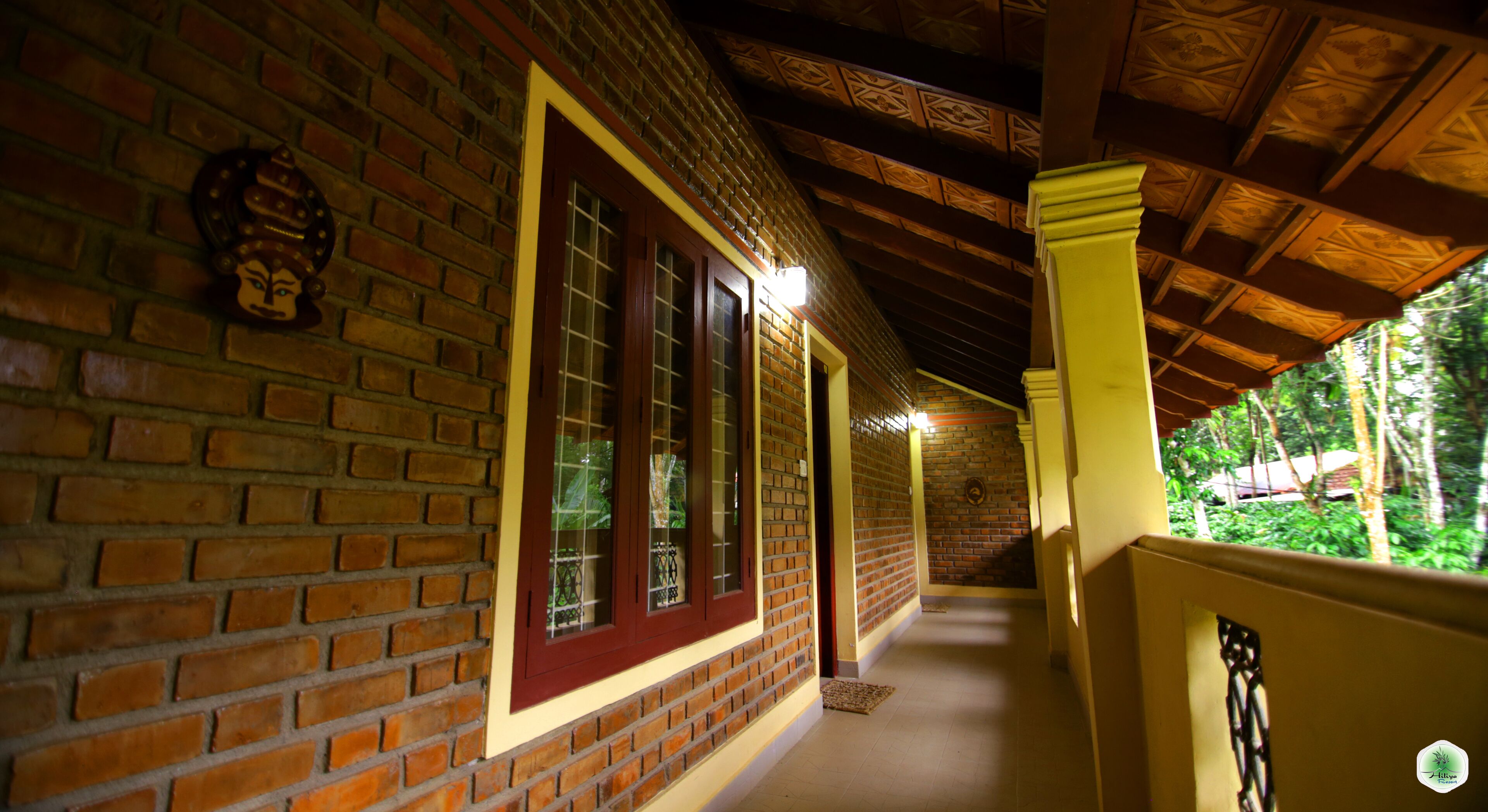 A corridor with brick walls, wooden beams, and a tiled floor.