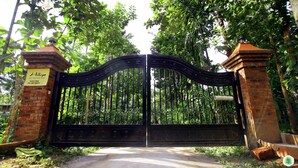 A gated entrance with a signboard, surrounded by lush greenery. - Hiliya Resort - Hostel (Sulthan Bathery)