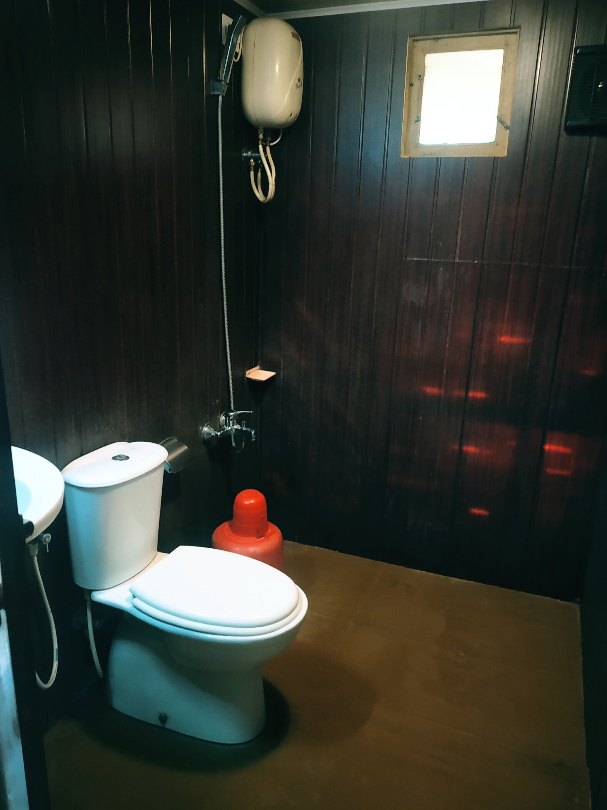 A compact bathroom with a toilet, a sink, and a shower.