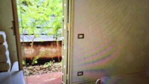 A room with a sliding glass door leading to a garden area. - New terrace sea view villa (Augusta)