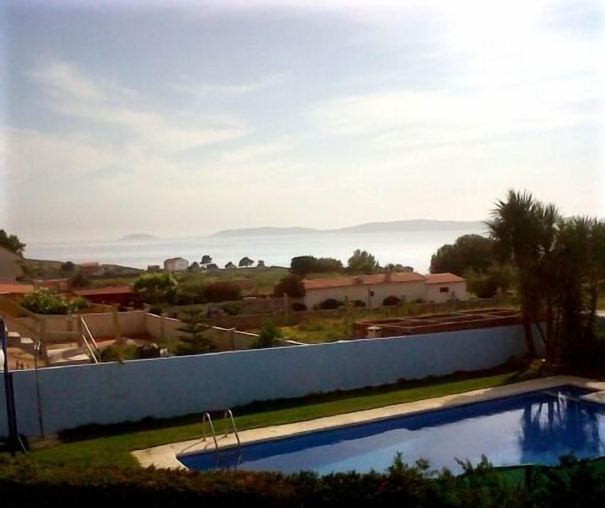 Ein Wohngebiet mit Schwimmbad, Häusern und Blick aufs Meer.