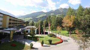Ein Hotel mit einem modernen Gebäude, einem Parkplatz und einem gepflegten Garten mit Fahnenmasten.