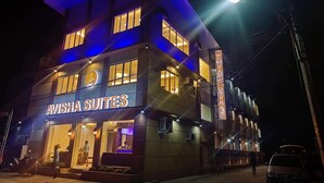 Un immeuble portant l’enseigne « AVISHA SUITES », ce qui indique qu’il s’agit d’un hôtel.