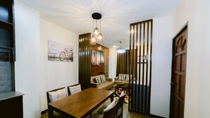 Un coin repas avec une table et des chaises en bois, un canapé et un élément décoratif mural.