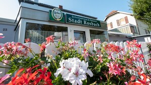 Un edificio con un cartel que dice 'Schnitzelhaus & Pension Stadt Rosbach'.