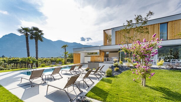 A modern house with a swimming pool, outdoor seating, and a well-maintained garden. - Alea Garda Lake Suite (Arco)
