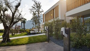 A modern building with a gravel driveway and a parking meter. - Alea Garda Lake Suite (Arco)