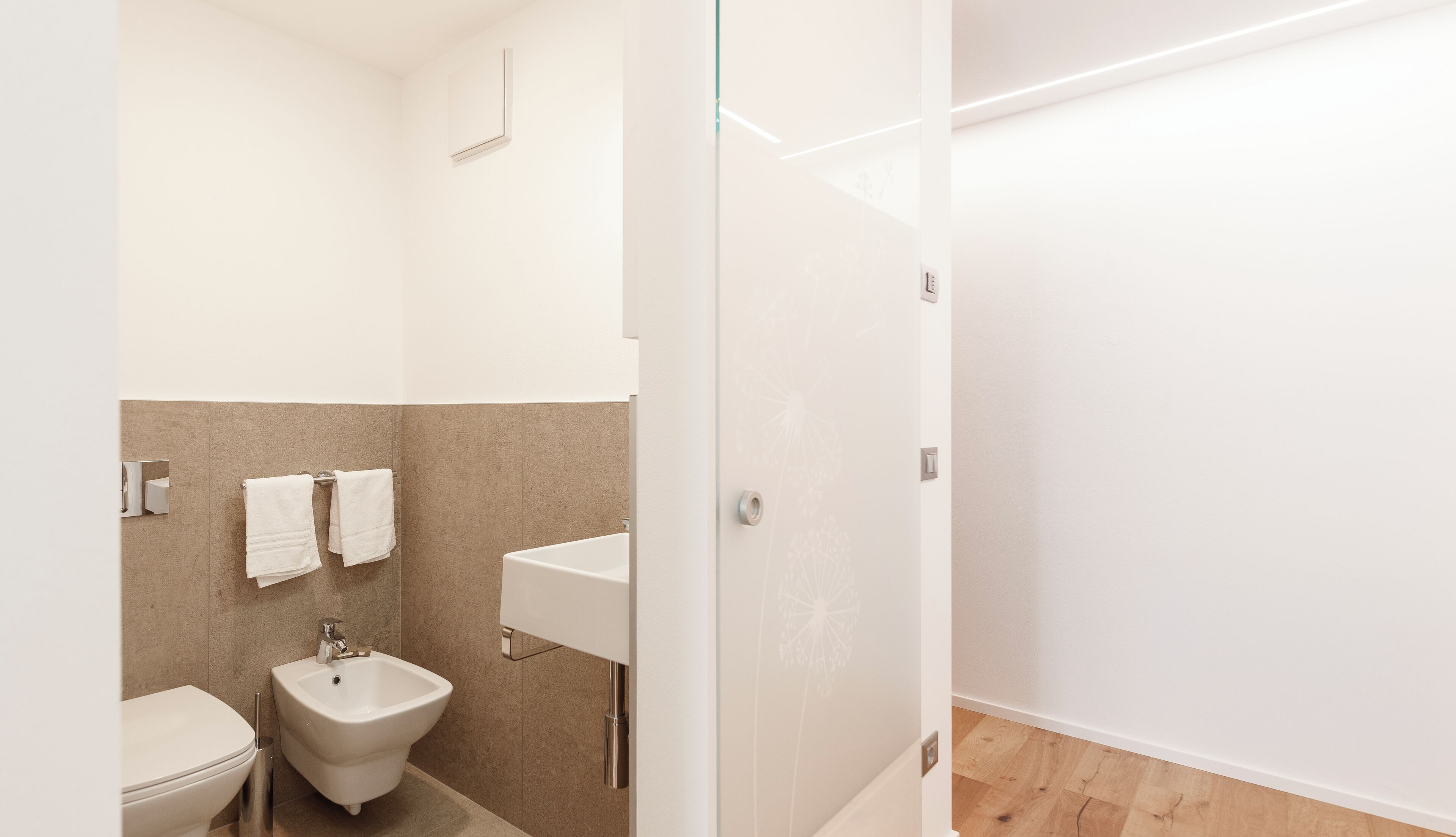 Un baño moderno con un bidé, un inodoro y un lavamanos.