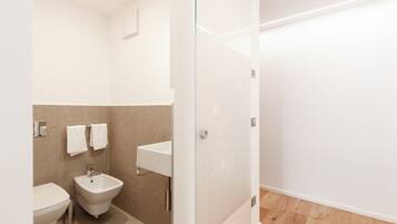 Un baño moderno con un bidé, un inodoro y un lavamanos.