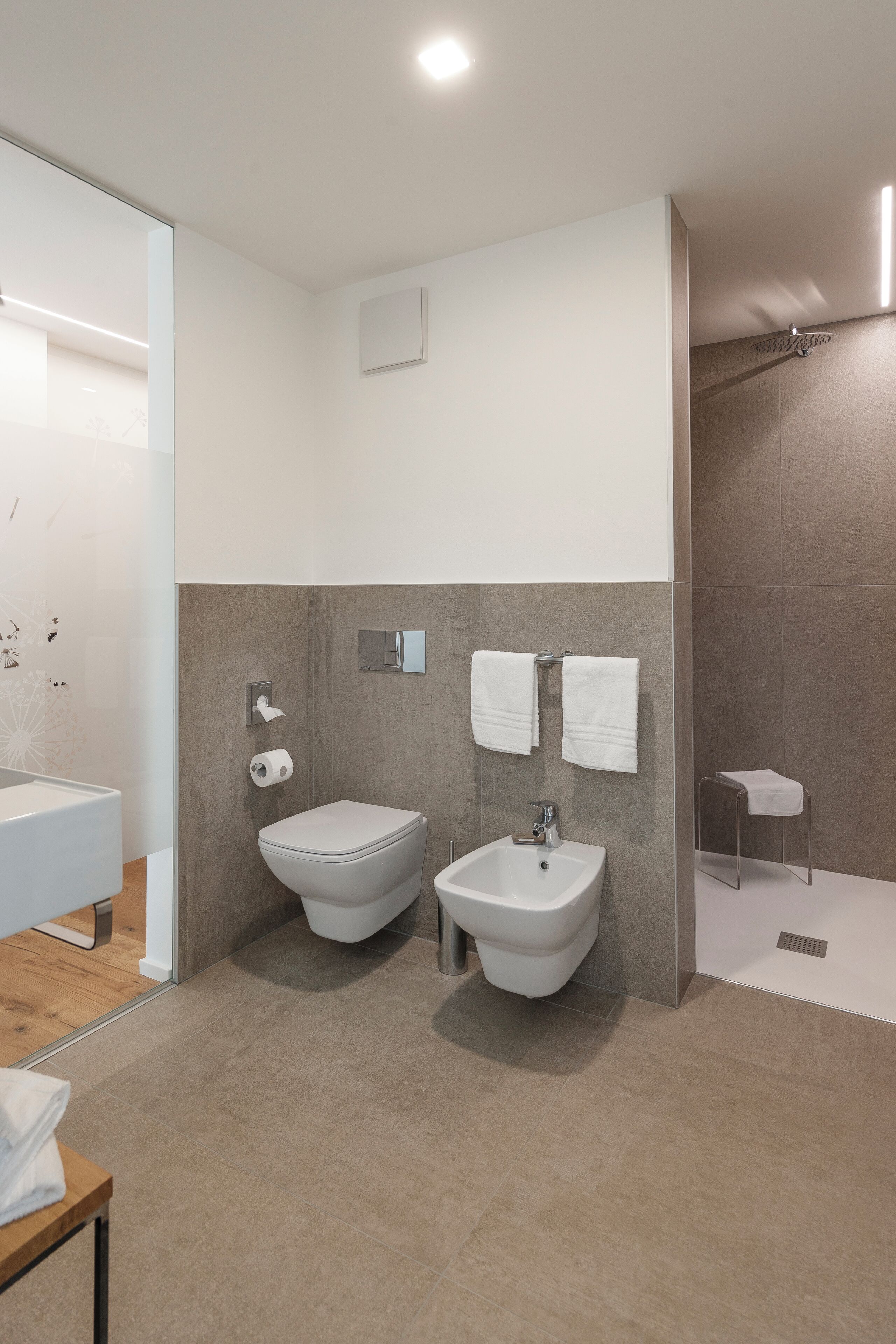Ein modernes Badezimmer mit integriertem Bidet, Toilette und Waschbecken.