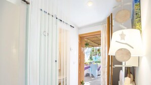 Un corridoio con una porta scorrevole in vetro che dà su una zona salotto all'aperto.