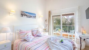 Una camera da letto con un letto, comodini, una finestra e vista sull'esterno.